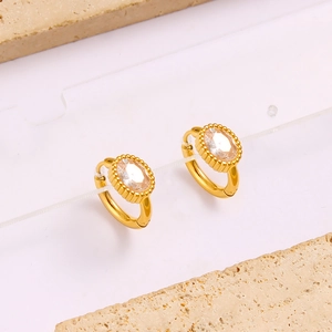 Detail of 18K gold-plated hoop earrings featuring oval-cut cubic zirconia in bezel setting