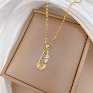 Detailed close-up of a gold paperclip pendant necklace set with clear zircon stones
