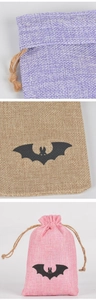 Detail of Halloween burlap drawstring bags with black bat prints in purple and brown