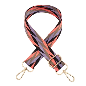 Macro shot of colorful geometric diamond pattern fabric strap with gold metal swivel hooks