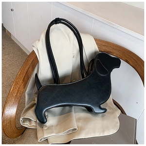 Detail view of a creative black dachshund-shaped shoulder bag in matte leather texture