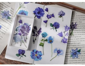 Detailed view of blue floral stickers and white storage box on vintage notebook