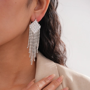 Elegant silver long tassel drop earrings with sparkling geometric crystals on a model