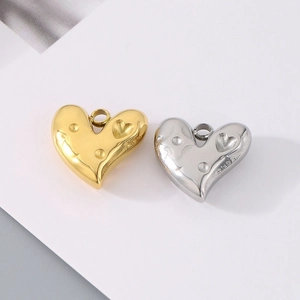 Dettaglio macro di ciondoli a cuore in oro e argento con motivi a faccina sorridente