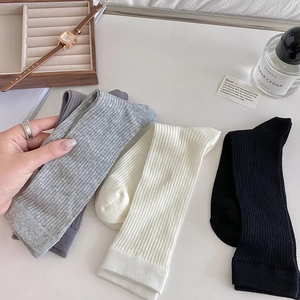 Detailed knit texture of vertically striped calf socks in grey, white and black options