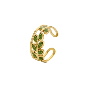 Detail of adjustable gold-plated titanium ring featuring green enamel leaf-shaped motifs