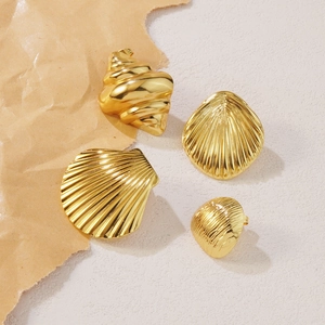Set of four gold stainless steel starfish and seashell stud earrings on a beige background