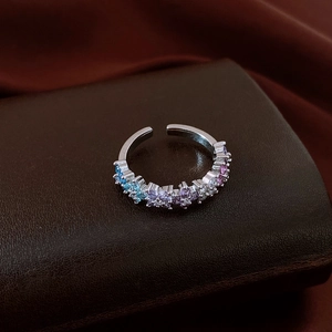 Dettaglio anello regolabile in argento con zirconi colorati su supporto in pelle