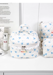Three-piece quilted white cosmetic bag set with blue bow print and pearl zipper detail