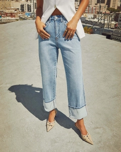 Detail of high-waist stretch straight jeans with stylish cuffed hems and light blue wash