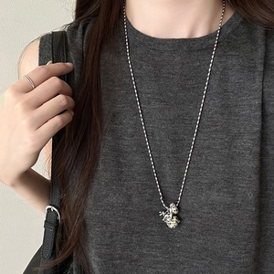 Detail of silver chain necklace featuring a Dalmation stone style patterned pendant