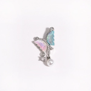 Detail of butterfly pendant with pink and blue wings, clear gems and hanging white pearl