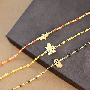 Detailed shot of three gold Halloween bracelets with beads, bat, ghost and castle charms