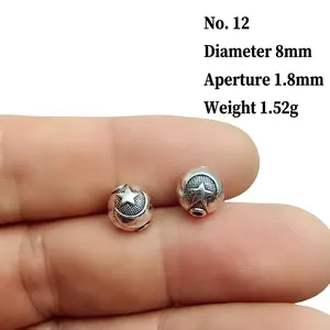 Macro shot of silver lantern beads with embossed star and moon patterns, size 12, 8mm diameter