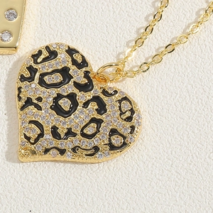 Macro detail of heart pendant with leopard print enamel and sparkling pavé crystals