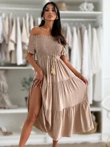 Detail of tiered skirt and off-shoulder smocked bodice on a beige bohemian dress