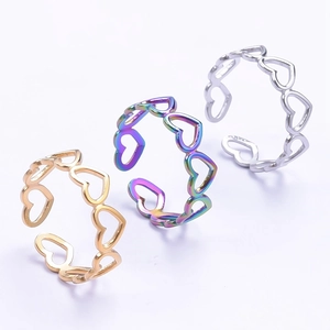 Detailed close-up of heart-shaped hollow rings in gold, silver, and rainbow finishes