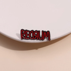 Gothic redrum enamel pin with blood dripping text on white display stand