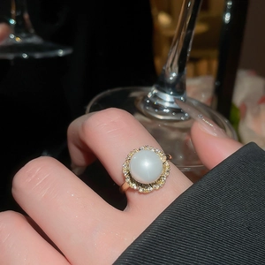 Elegant gold flower ring with round opal and zircon stones worn on hand at dinner