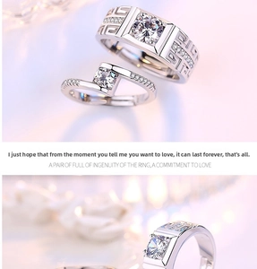 Detailed view of silver couple rings with Greek fret pattern and round-cut crystals