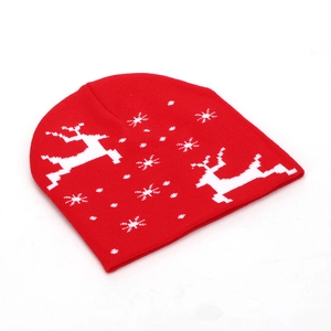 Close-up of red Christmas beanie featuring white knitted reindeer and snowflake patterns