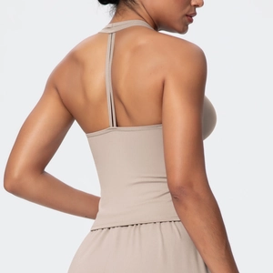 Detail of beige yoga set featuring a cross-back sports bra and high-waist shorts