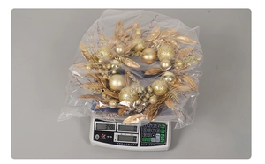 Detail shot of golden Christmas wreath with decorative balls on a digital scale