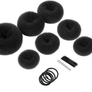 Detail set of black hair bun makers, U-shaped pins, and elastic bands on white background
