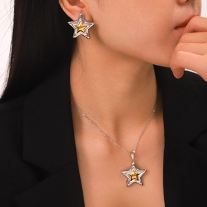 Two-tone stainless steel star pendant necklace and earrings set shown on model