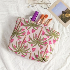 Rosa Jacquard Kosmetiktasche mit Palmenmuster und Pinseln in stilvoller Dekoration