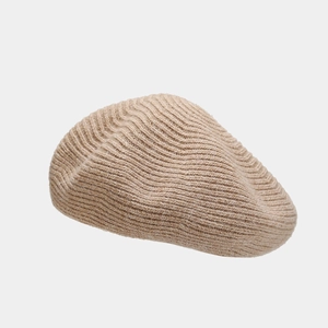 Detail showing the fine knitted wool texture and soft beige finish of the beret hat