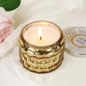 Velvet Rose scented soy candle in a golden embossed glass jar on elegant marble base