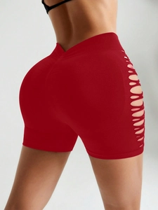Détail du short de yoga rouge à taille haute avec découpes latérales et effet push-up