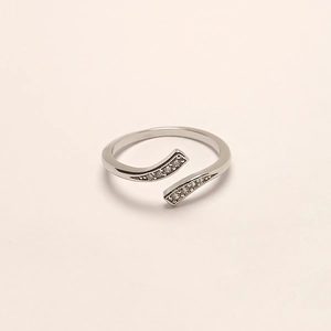 Detail of silver plated open ring featuring minimalist zircon rows on a beige background