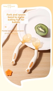 Close-up of bendable cream and orange baby spork training set on a wooden table