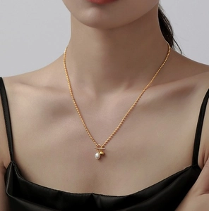 Detail of 18k gold pearl necklace featuring a toggle clasp and elegant pendant design