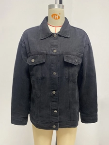 Detail of the vintage metal buttons and flap pockets on black denim jacket for women