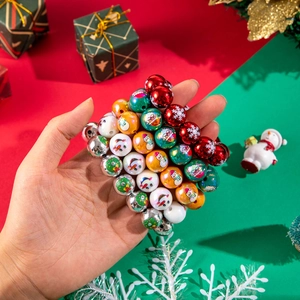Detailed view of colorful Christmas resin beads with snowman and snowflake prints held by hand