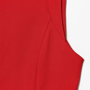 Gros plan sur les coutures de l'épaule et la texture de la maille du haut sans manches rouge