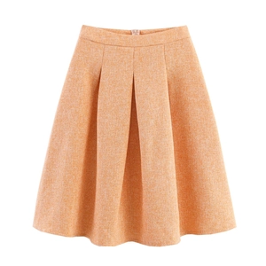 Détail d'une mini-jupe trapèze orange avec taille plissée et tissu à texture tissée