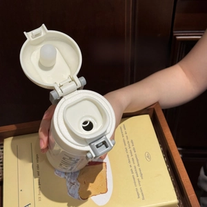 Detail of the direct drinking spout and flip-top lock on the cream white insulated bottle