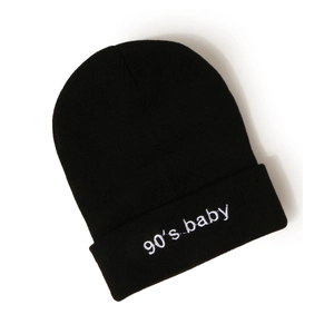 Détail de la broderie 90's baby sur le revers d'un bonnet en maille côtelée noir