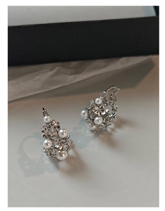 Detailed macro view of silver floral earrings with white pearls and sparkling cubic zirconia