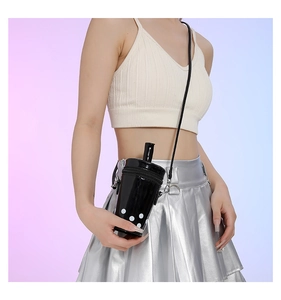 Detail of creative bubble tea cup shoulder bag in black patent leather with straw decor