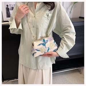 Detail of vintage floral jacquard kiss-lock bag with delicate gold chain strap