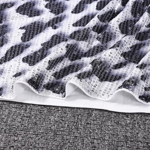 Primer plano del estampado de leopardo blanco con lentejuelas y detalles de costura