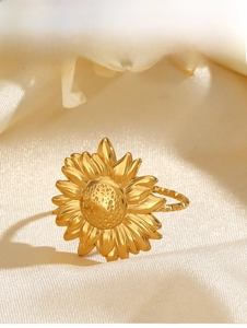 Gros plan d'une bague tournesol dorée aux pétales détaillés sur fond de soie douce