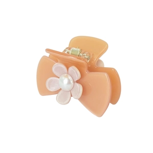 Detail of peach cream hair claw clip with light pink flower and central white pearl accent