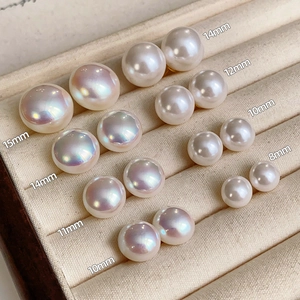 Detailed comparison of various sizes of iridescent pearls from 8mm to 15mm on velvet