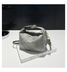 Detail of washed grey canvas shoulder bag with metallic buckle and adjustable strap